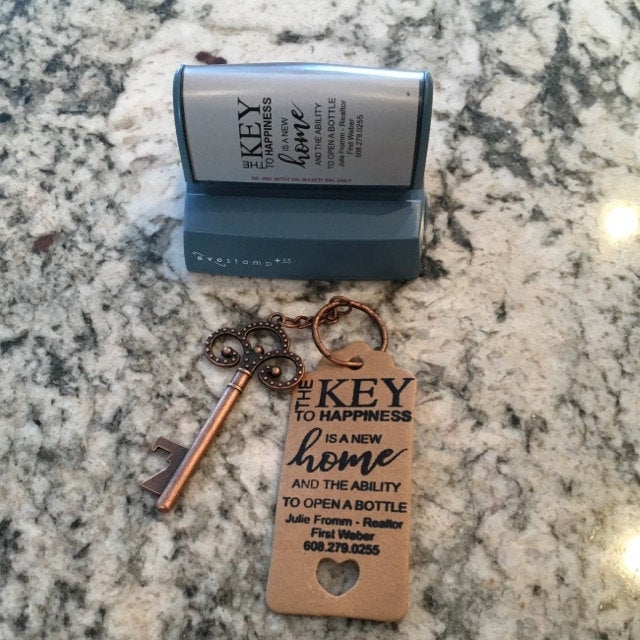 picture of 2000 Plus HD pre-inked stamp above an old fashioned key and key-tag with black stamp impression