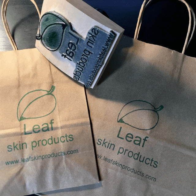 Wood Rocker Stamp next to Leaf skin products paper bags.